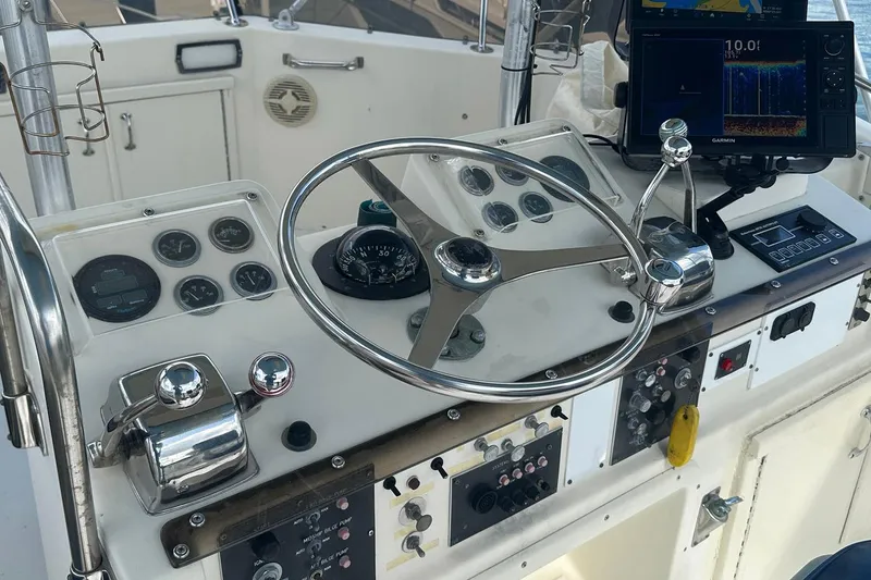 Slide: The Image of 1981 Hatteras 43 Convertible helm with steering wheel, gauges, and navigation equipment. - 9