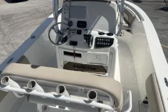 Slide: The Image of 2023 NauticStar 2302 Legacy boat interior with steering console and rod holders. - 12