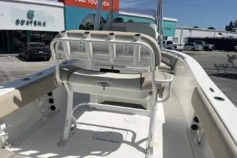 Slide: The Image of 2023 NauticStar 2302 Legacy boat interior with seating and console, displayed outdoors. - 13