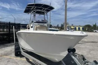 Slide: The Image of 2023 NauticStar 2302 Legacy boat on trailer, parked outdoors under blue sky. - 3