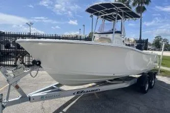 Slide: The Image of 2023 NauticStar 2302 Legacy boat on trailer, parked outdoors under clear sky. - 4