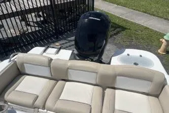 Slide: The Image of 2023 NauticStar 2302 Legacy boat with cushioned seating and outboard motor. - 7