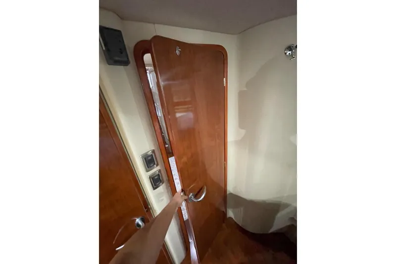 Slide: The Image of Interior view of 2004 Sea Ray 480 Sedan Bridge with wooden door and handle. - 20