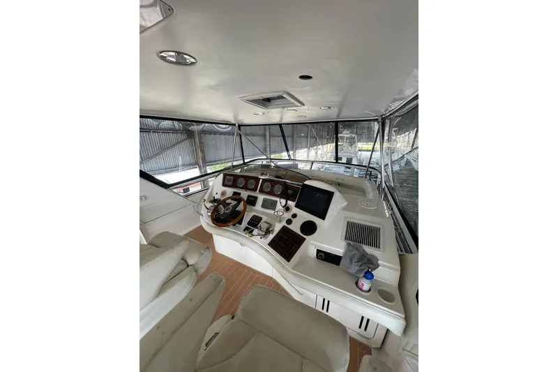 Slide: The Image of Interior view of 2004 Sea Ray 480 Sedan Bridge yacht cockpit with steering and controls. - 21