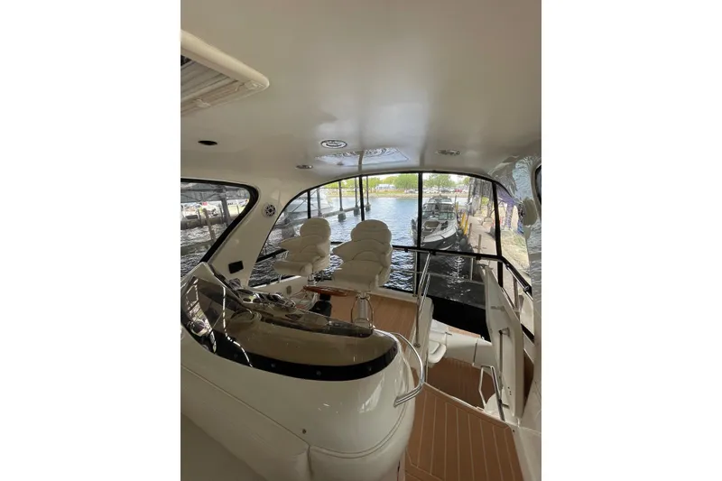 Slide: The Image of Interior view of 2004 Sea Ray 480 Sedan Bridge yacht with helm and seating area. - 23