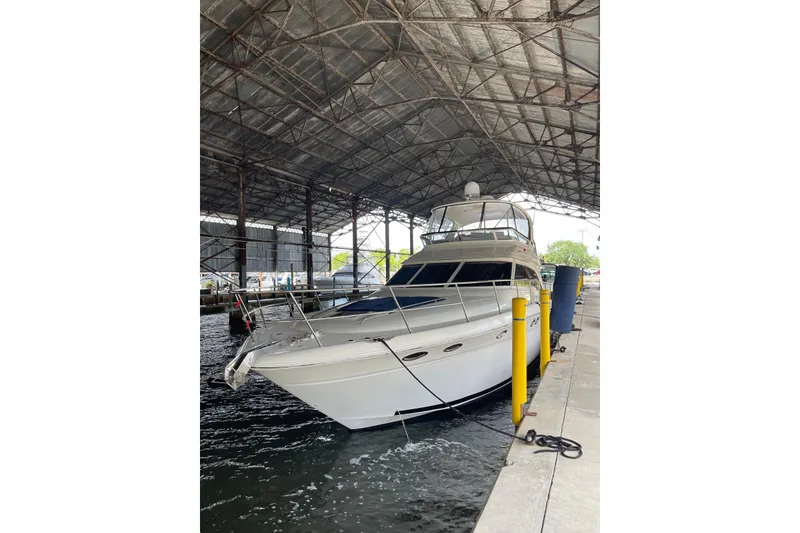 Slide: The Image of 2004 Sea Ray 480 Sedan Bridge yacht docked under a covered marina. - 3