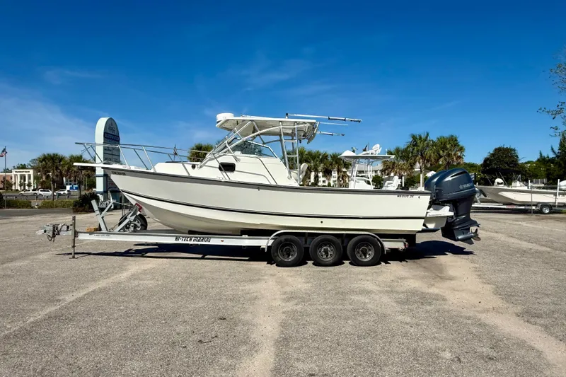 Slide: The Image of 1988 Negus 26 boat on trailer in sunny outdoor setting. - 1