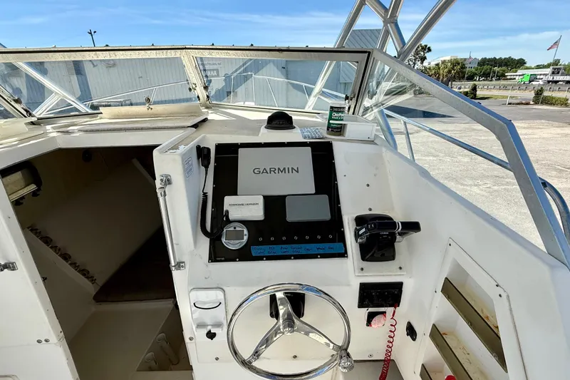 Slide: The Image of Cockpit of 1988 Negus 26 boat featuring Garmin navigation system and steering wheel. - 10