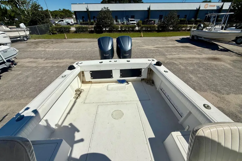 Slide: The Image of 1988 Negus 26 boat with dual 300 horsepower engines, parked outdoors. - 11