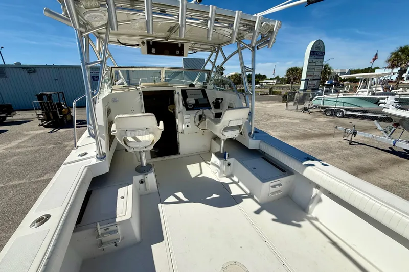 Slide: The Image of 1988 Negus 26 boat interior with helm seats, docked at marina under clear sky. - 12