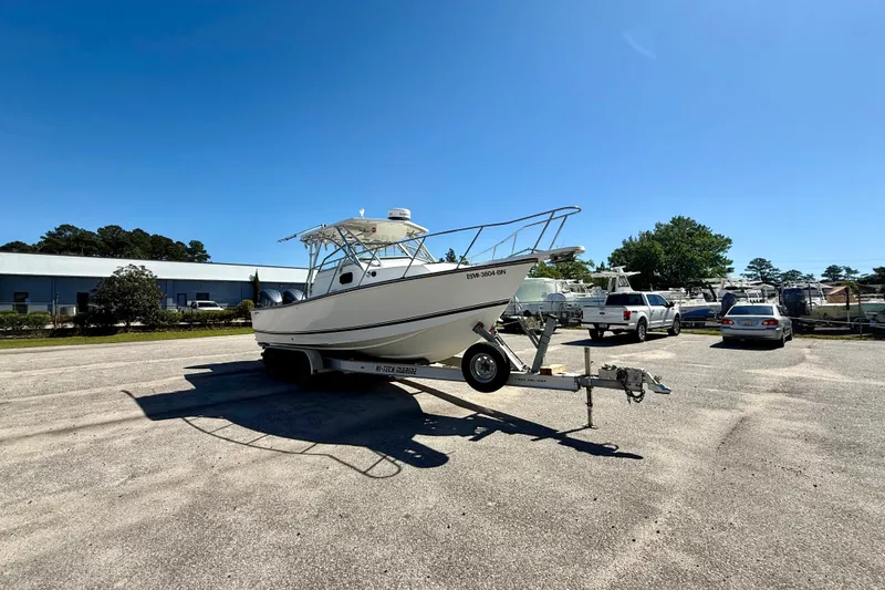 Slide: The Image of 1988 Negus 26 boat on trailer in parking lot under clear blue sky. - 6