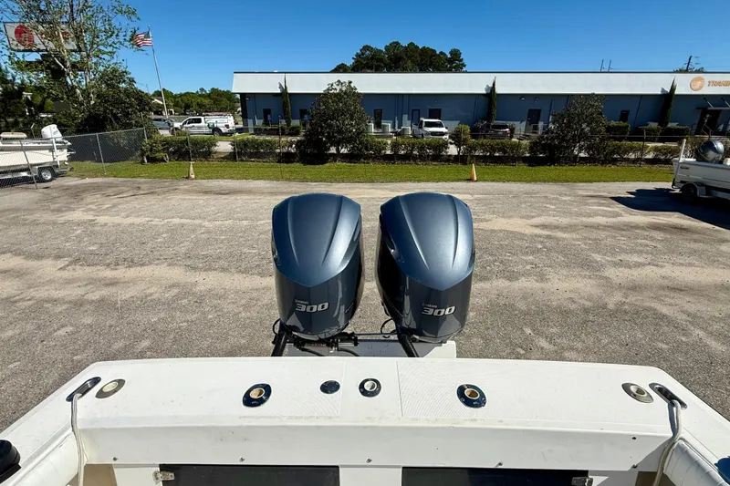 Slide: The Image of Twin Yamaha 300 outboard motors on a 1988 Negus 26 boat, parked outdoors. - 8