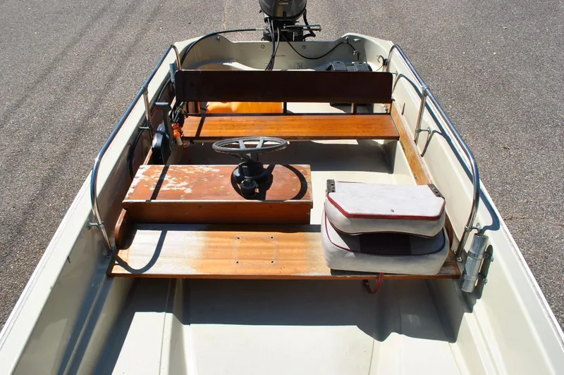 Slide: The Image of 1976 Boston Whaler 15 boat interior with wooden seats and steering wheel. - 10