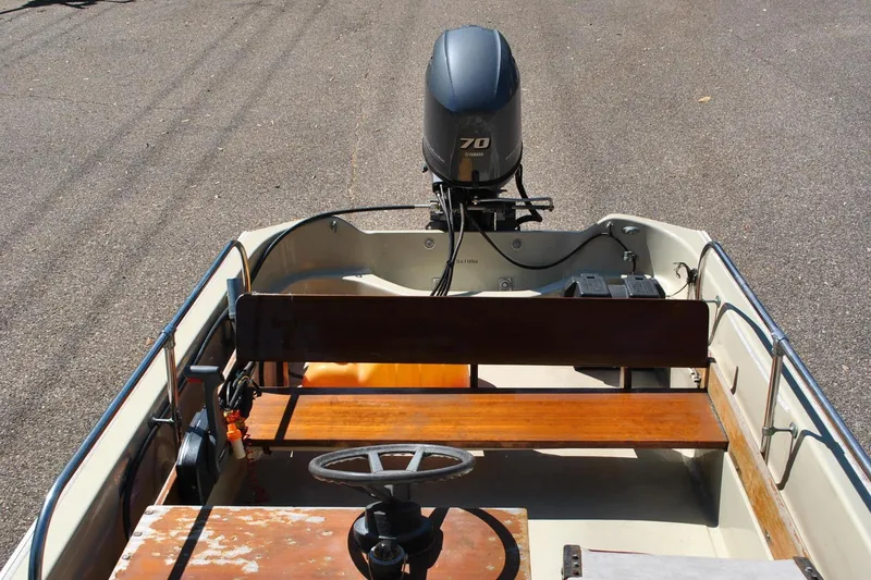 Slide: The Image of 1976 Boston Whaler 15 boat with Yamaha 70 outboard motor, wooden seats, and steering wheel. - 11