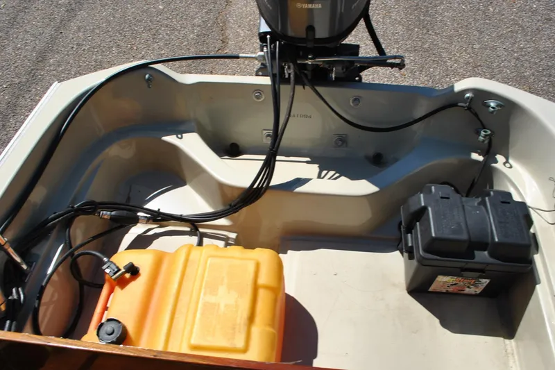 Slide: The Image of 1976 Boston Whaler 15 boat interior with Yamaha motor, fuel tank, and battery. - 12