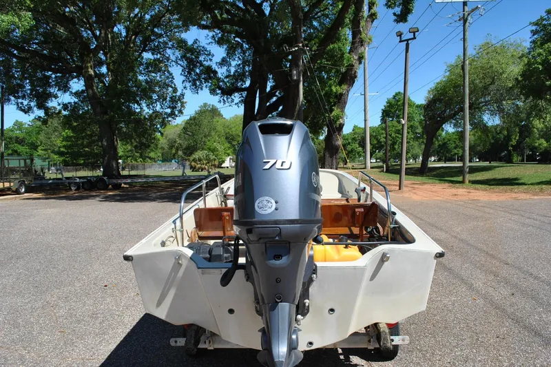 Slide: The Image of 1976 Boston Whaler 15 boat with Yamaha 70 outboard motor in a park setting. - 17