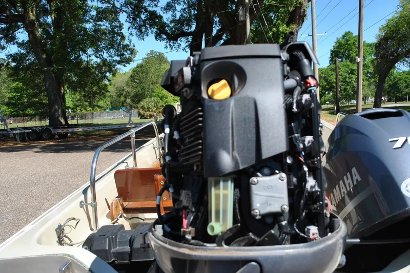 Slide: The Image of 1976 Boston Whaler 15 boat with Yamaha outboard motor in a sunny outdoor setting. - 22
