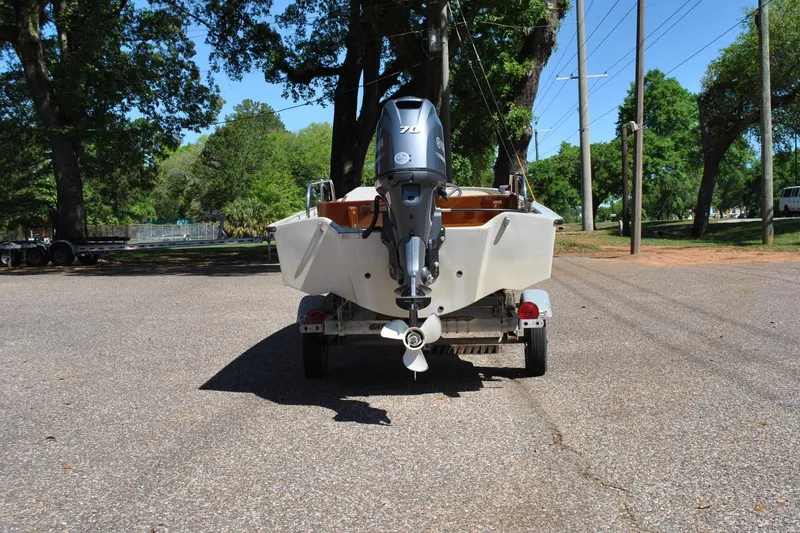 Slide: The Image of 1976 Boston Whaler 15 boat on trailer, parked outdoors with trees in background. - 7