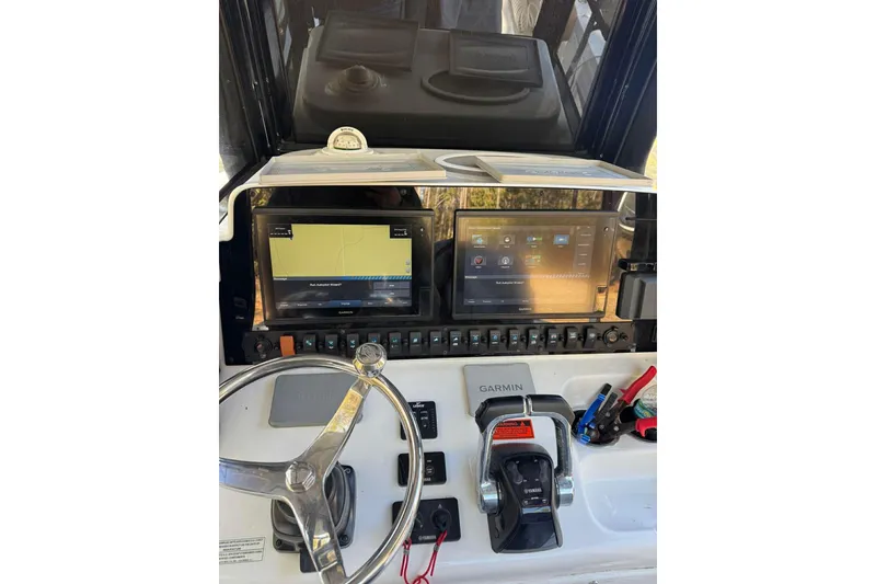 Slide: The Image of 2020 Sea Hunt Gamefish 27 dashboard with Garmin navigation and Yamaha controls. - 16