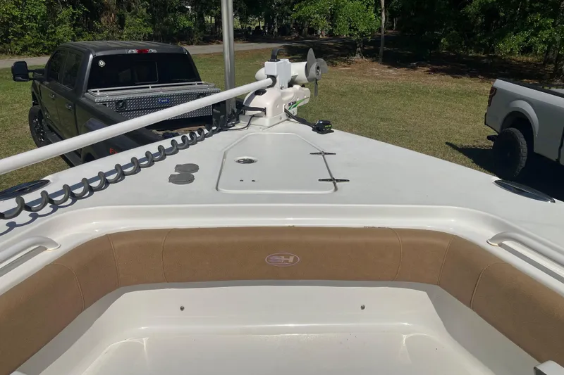 Slide: The Image of 2020 Sea Hunt Gamefish 27 Forward Seating boat with trucks in the background. - 31