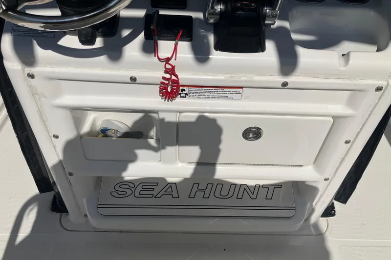 Slide: The Image of Control panel of a 2020 Sea Hunt Gamefish 27 boat with steering wheel and storage. - 61