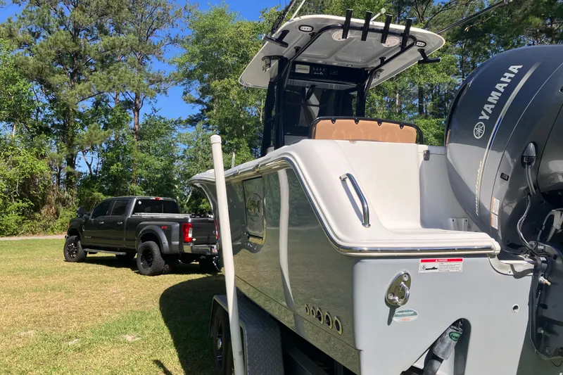 Slide: The Image of 2020 Sea Hunt Gamefish 27 boat with Yamaha engine, parked near a black truck. - 74
