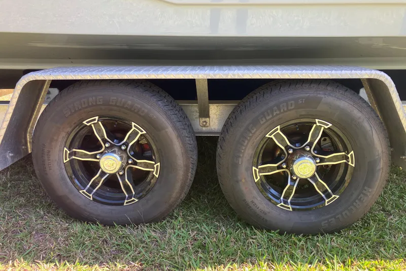 Slide: The Image of Trailer wheels of a 2020 Sea Hunt Gamefish 27 boat on grass. - 76