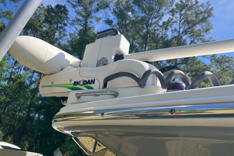 Slide: The Image of 2020 Sea Hunt Gamefish 27 with Rhodan trolling motor, set against a forest backdrop. - 79