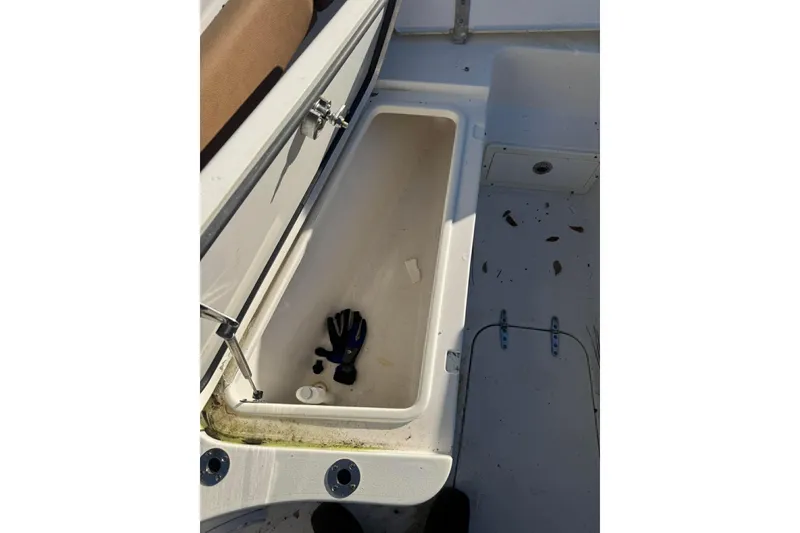 Slide: The Image of Open storage compartment on 2020 Sea Hunt Gamefish 27 boat with glove inside. - 8