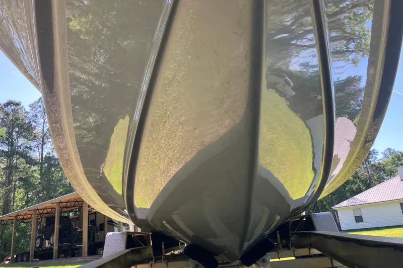 Slide: The Image of 2020 Sea Hunt Gamefish 27 boat hull, reflecting trees and sky, on a trailer. - 83