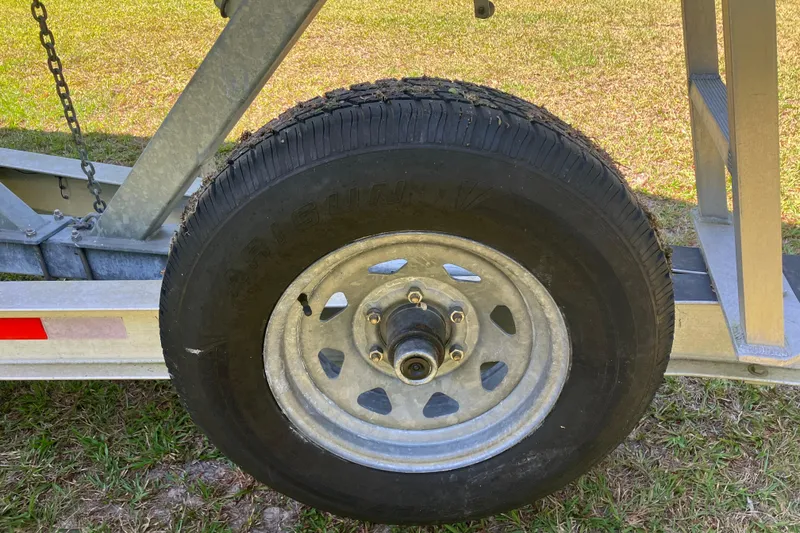 Slide: The Image of Trailer wheel for 2020 Sea Hunt Gamefish 27 Forward Seating boat on grass. - 84