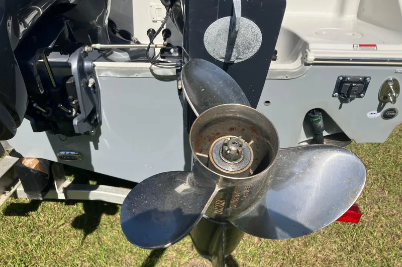 Slide: The Image of Propeller of a 2020 Sea Hunt Gamefish 27 boat on grass, showcasing engine details. - 87