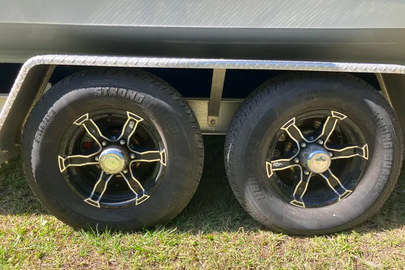Slide: The Image of Trailer wheels of a 2020 Sea Hunt Gamefish 27 Forward Seating boat on grass. - 93