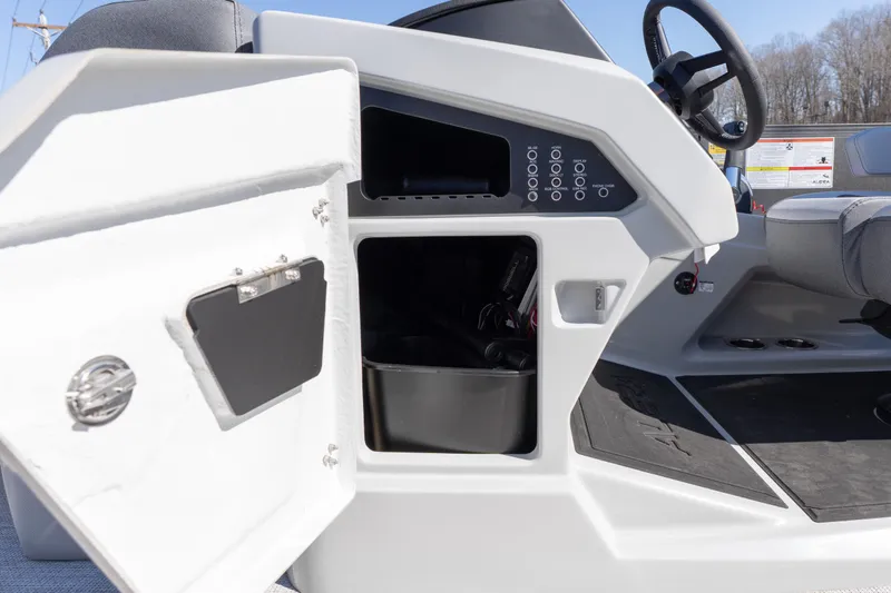 Slide: The Image of 2026 Alera M23Q boat dashboard with open storage compartment and steering wheel. - 16