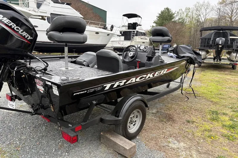 Slide: The Image of 2025 Tracker Pro 170 boat on trailer, parked outdoors near other boats. - 5