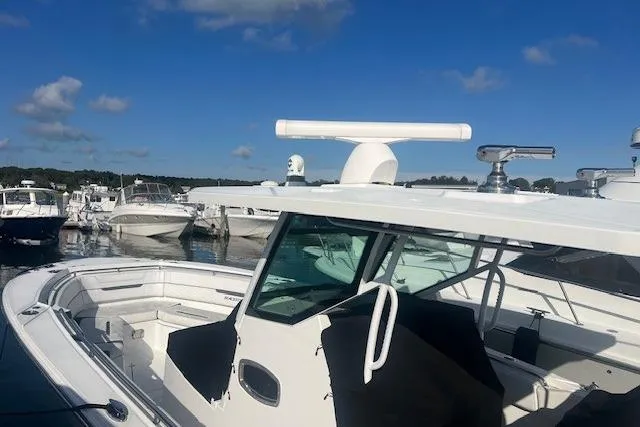 Slide: The Image of 2022 Blackfin 332 CC boat docked at marina under clear blue sky. - 19