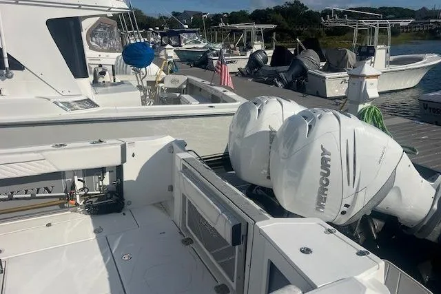 Slide: The Image of 2022 Blackfin 332 CC boat with twin Mercury engines docked at a marina. - 20