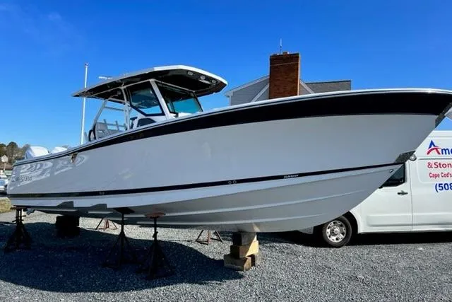 Slide: The Image of 2022 Blackfin 332 CC boat on stands, displayed outdoors under clear blue sky. - 3