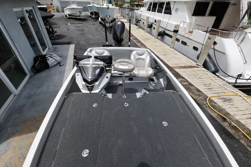 Slide: The Image of 2020 Ranger Z520L boat docked, featuring spacious deck and seating. - 18