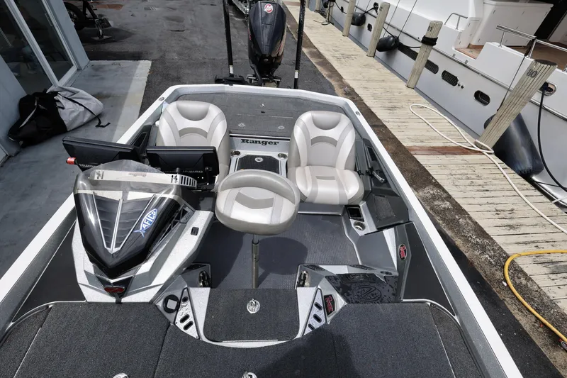 Slide: The Image of 2020 Ranger Z520L boat interior with seating and control panel at dockside. - 19
