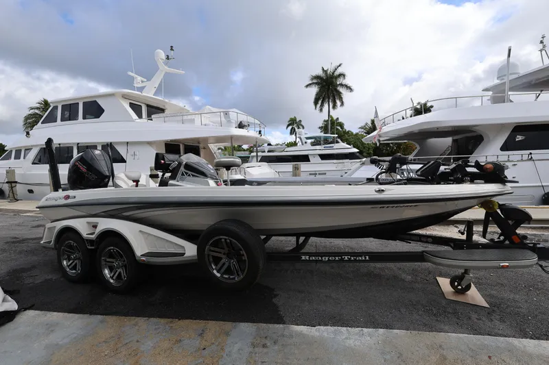Slide: The Image of 2020 Ranger Z520L boat on trailer, docked near luxury yachts and palm trees. - 6