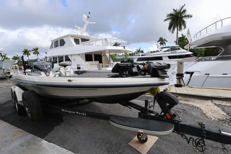 Slide: The Image of 2020 Ranger Z520L boat on trailer, docked near luxury yachts and palm trees. - 7