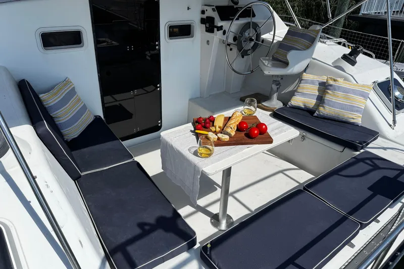 Slide: The Image of Cozy seating area on 1991 PDQ 36 yacht with snacks and drinks on table. - 10