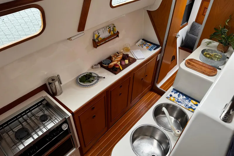 Slide: The Image of Interior of a 1991 PDQ 36 yacht kitchen with wooden cabinets and modern amenities. - 12