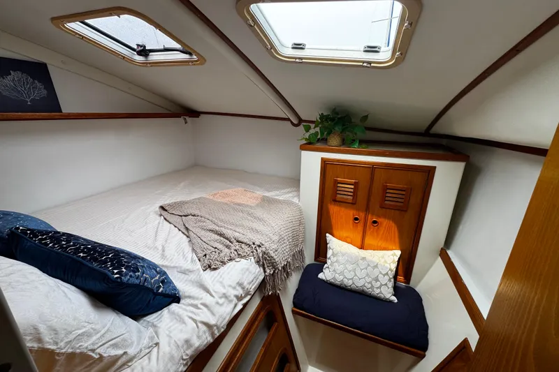 Slide: The Image of Cozy cabin interior of 1991 PDQ 36 sailboat with bed, cushions, and wooden storage. - 13