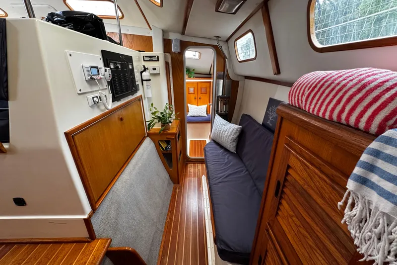 Slide: The Image of Interior of a 1991 PDQ 36 sailboat with cozy seating and wooden accents. - 16
