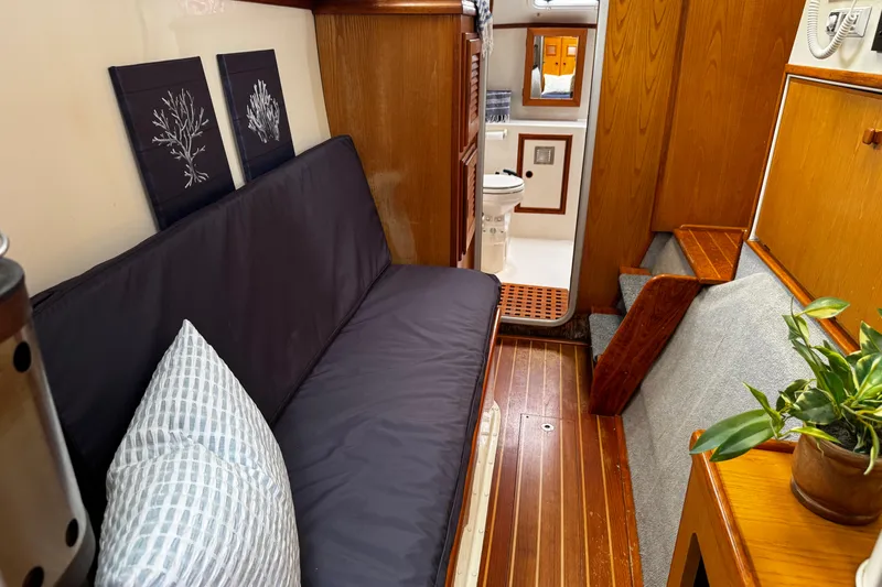 Slide: The Image of Cozy interior of a 1991 PDQ 36 boat with seating, decor, and bathroom. - 17