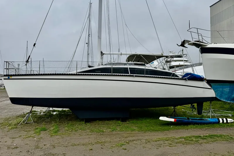 Slide: The Image of 1991 PDQ 36 sailboat on land, overcast sky, marina background. - 3