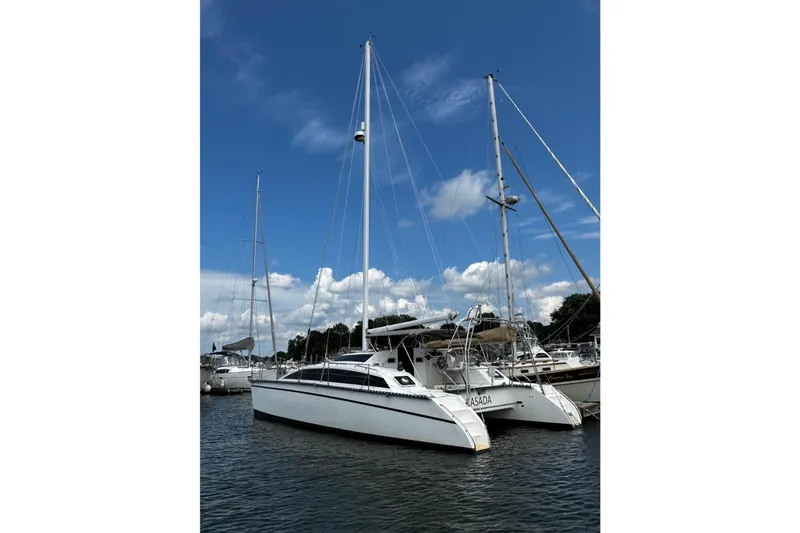Slide: The Image of Sailboats docked at marina under blue sky, featuring 1991 PDQ 36 catamaran. - 4