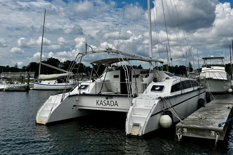 Slide: The Image of Catamaran "Kasada" docked at marina, PDQ 36 model, 1991, under cloudy sky. - 6